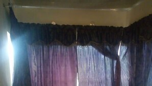 A bedroom with a bed, pillows, and curtains. - Senior Chief Wambugu Palace (Marua)
