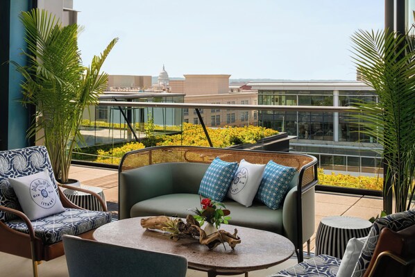 A rooftop terrace with a seating area, a view of a cityscape, and a decorative plant centerpiece. - AC Hotel by Marriott Washington DC Convention Center (Washington)