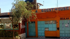 Ein Gästehaus mit einem Schild, auf dem 'GUESTHOUSE & BEULAH' steht, und einem sichtbaren Hauseingang.