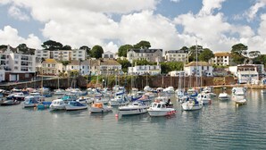 Un port de plaisance où de nombreux bateaux sont amarrés, entouré de bâtiments résidentiels et d’arbres.