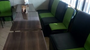 Un espace détente avec une table en bois foncé et des canapés verts à coussins.
