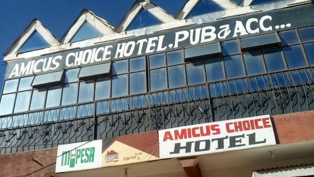 Un hôtel dont l’enseigne, bien visible, porte l’inscription « Amicus Choice Hotel ».