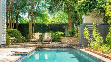 Una piscina al aire libre, sillones reclinables de piscina