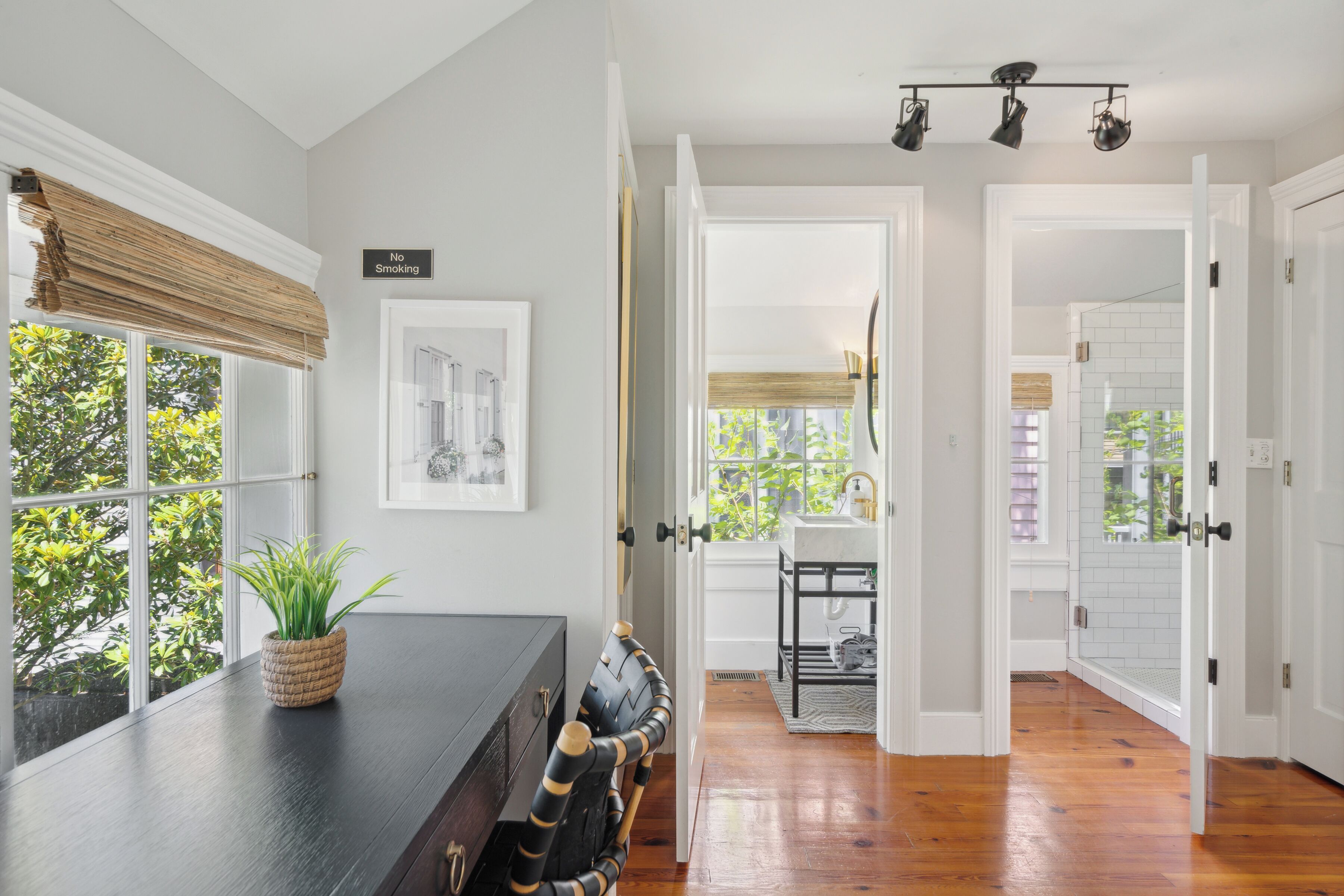A modern kitchen with a dark countertop, a woven basket with green plants, and a black chair with gold accents.