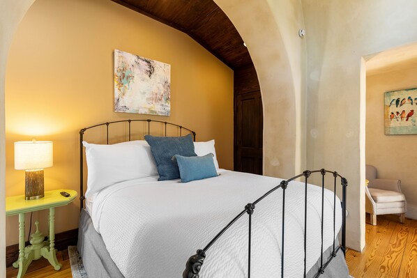 Un dormitorio con una cama, una mesita de noche, una lámpara y una silla.