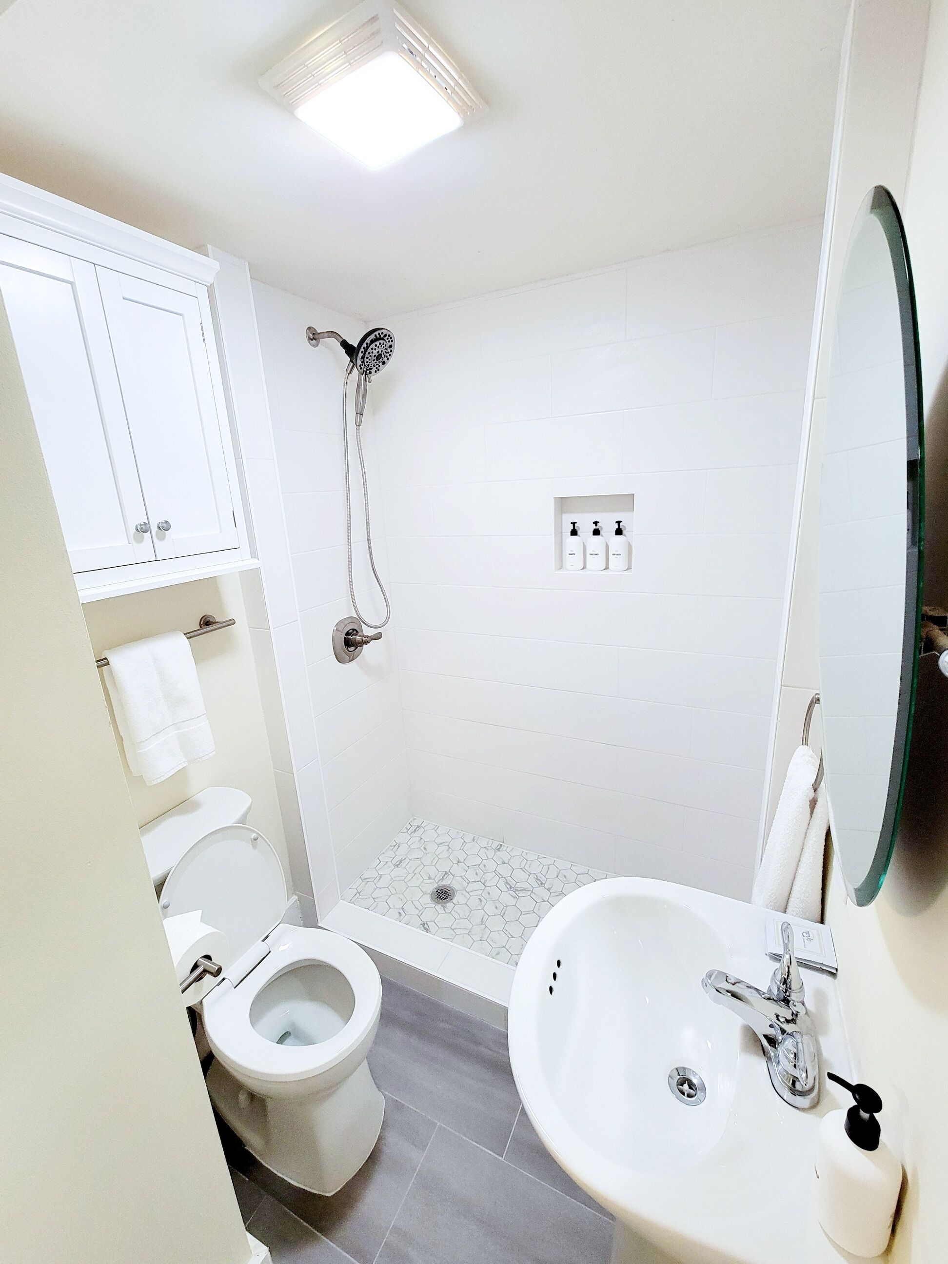 Un baño moderno con inodoro, ducha y lavamanos.