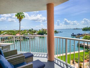 Enjoy breathtaking views of the marina from this balcony, complete with comfortable wicker furniture.