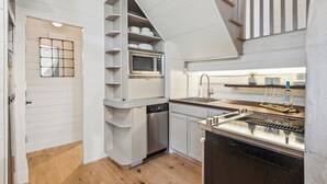 A compact kitchen with a built-in microwave, dishwasher, and a small sink area. - Revitalized Historical Southern Residence (Charleston)