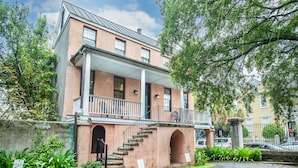 A two-story building with a balcony and a staircase leading to an entrance. - Revitalized Historical Southern Residence (Charleston)