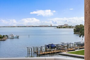 A marina with boats docked, a clear sky, and a distant cityscape. - Coastal Escape | Pool, Tennis, + Shuffleboard (St. Pete Beach)