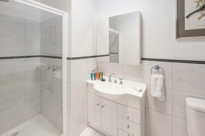 Bathtub, hair dryer, towels, shampoo