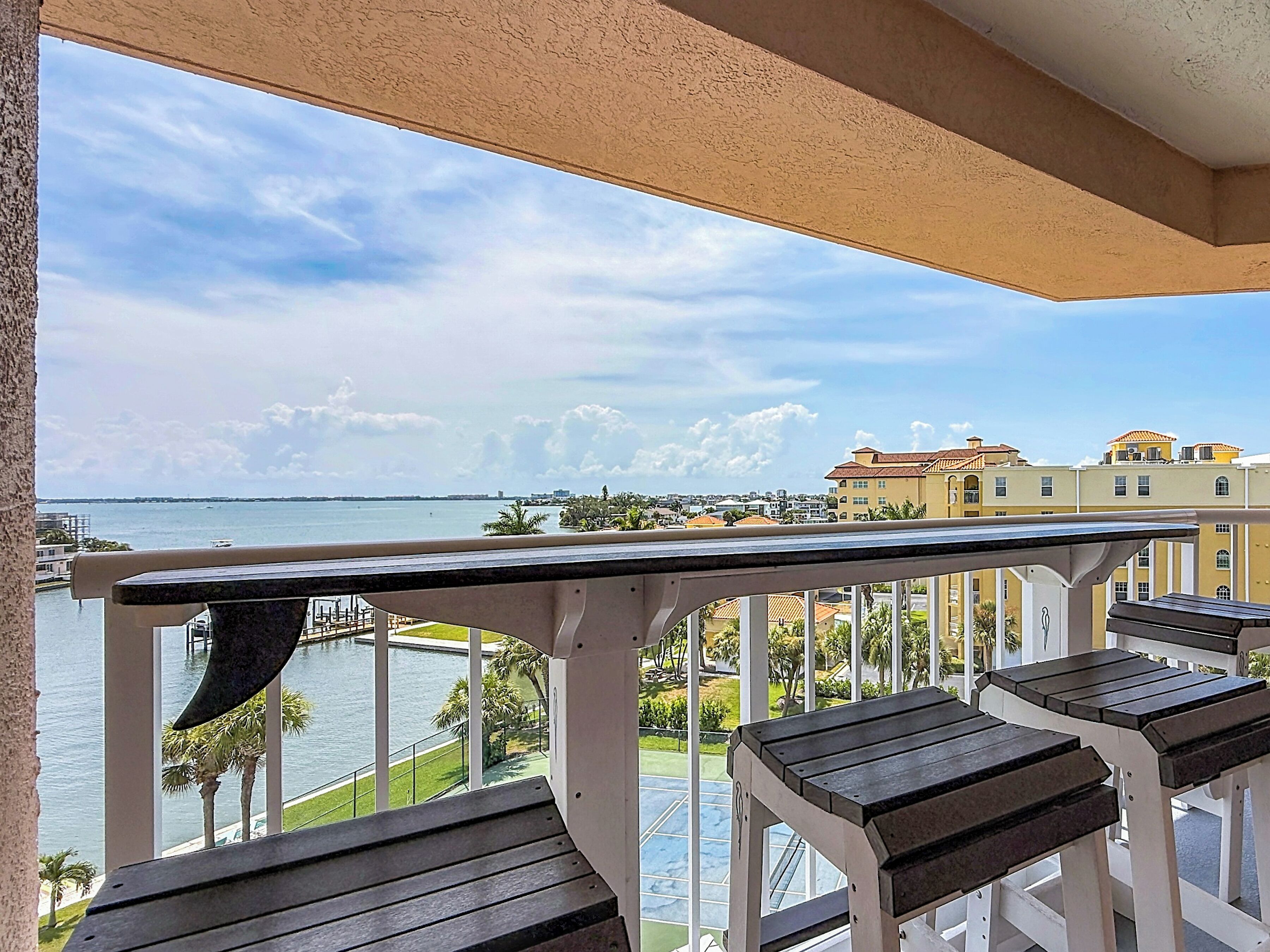 A balcony with a view of a body of water and buildings in the distance.