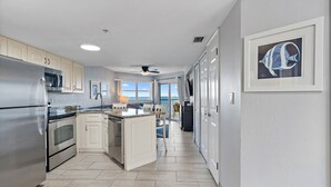 Een moderne keuken met roestvrijstalen apparatuur, een centraal eiland en uitzicht naar buiten.
