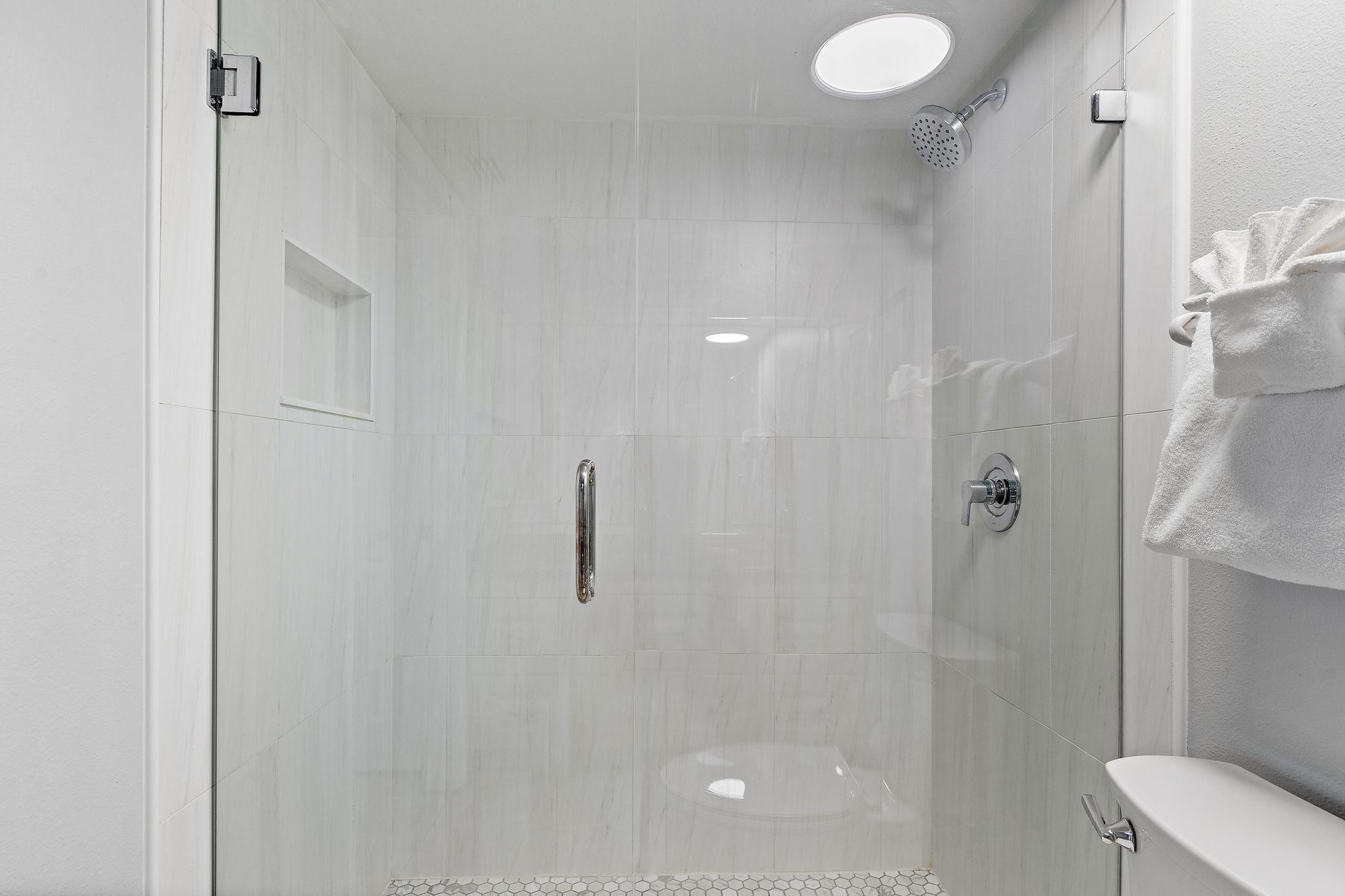 Un bagno moderno con doccia vetrata, un water e un lavandino.