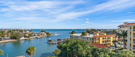 A waterfront property with a tennis court, marina, and residential buildings.