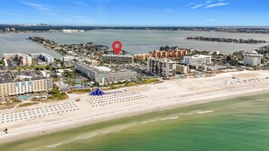 Een kuststadsgezicht met een hotel aan het strand, een jachthaven en een groot wateroppervlak.