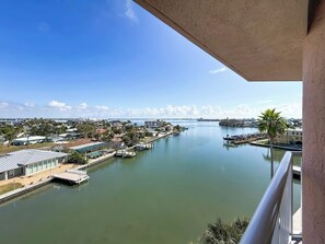 A river with docks and a marina, surrounded by residential buildings and greenery. - Upscale Penthouse | Waterfront Views (St. Pete Beach)
