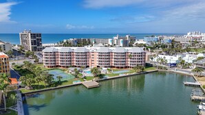 Um hotel à beira-mar com várias varandas, quadra de tênis e marina.