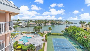 Un hôtel doté d’une piscine, d’un court de tennis et offrant une vue sur un lac et la ville.