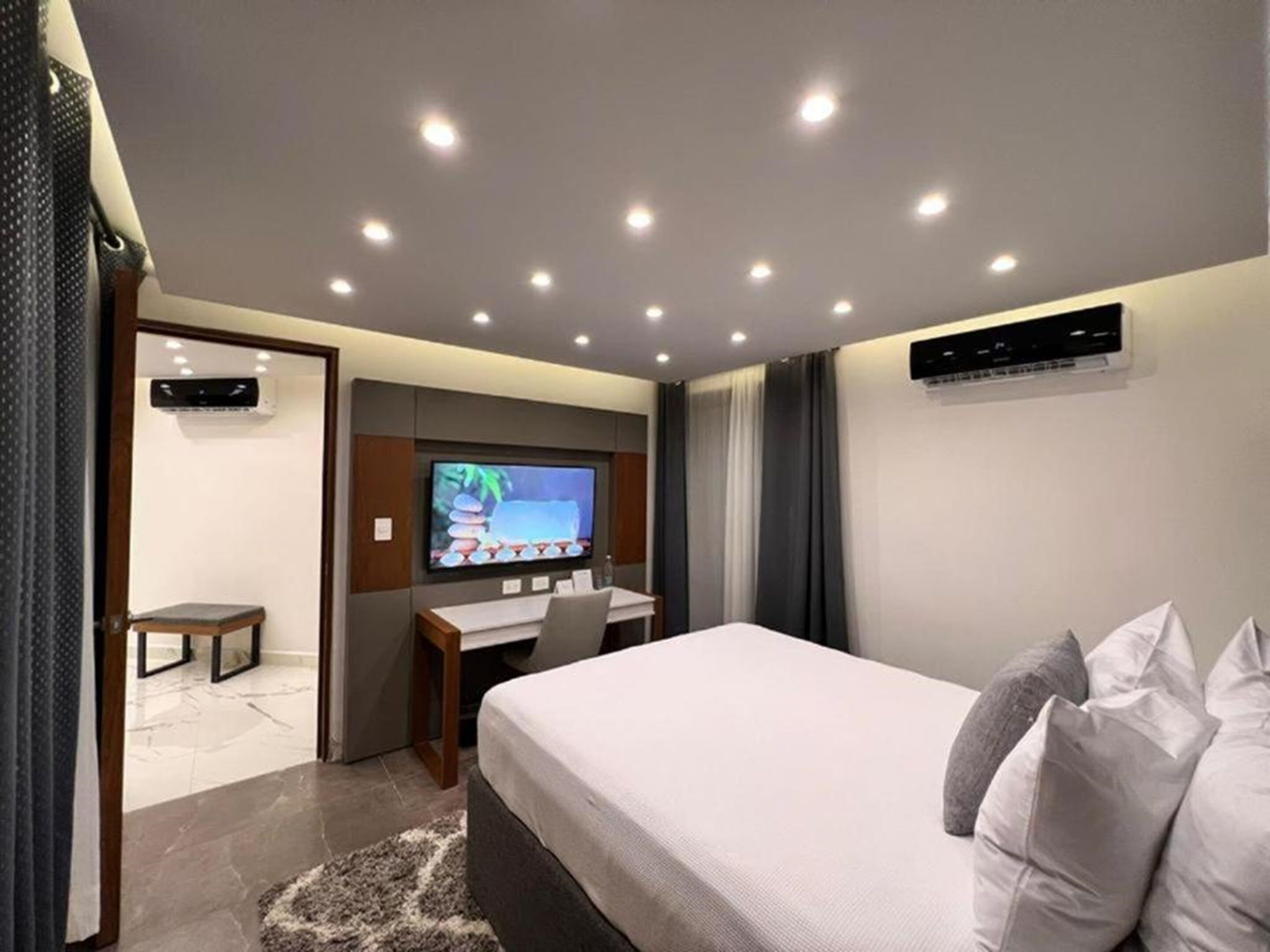 Ein modernes Hotelzimmer mit Bett, Schreibtisch und Fernseher.
