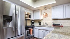 A modern kitchen with stainless steel appliances, white cabinetry, and a granite countertop. - Luxe & Spacious Gem: Pool ~ 15min to Downtown ~ Parking! (Tucson)