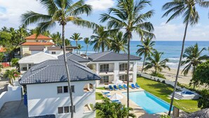 A resort with a pool, palm trees, and a beach view.