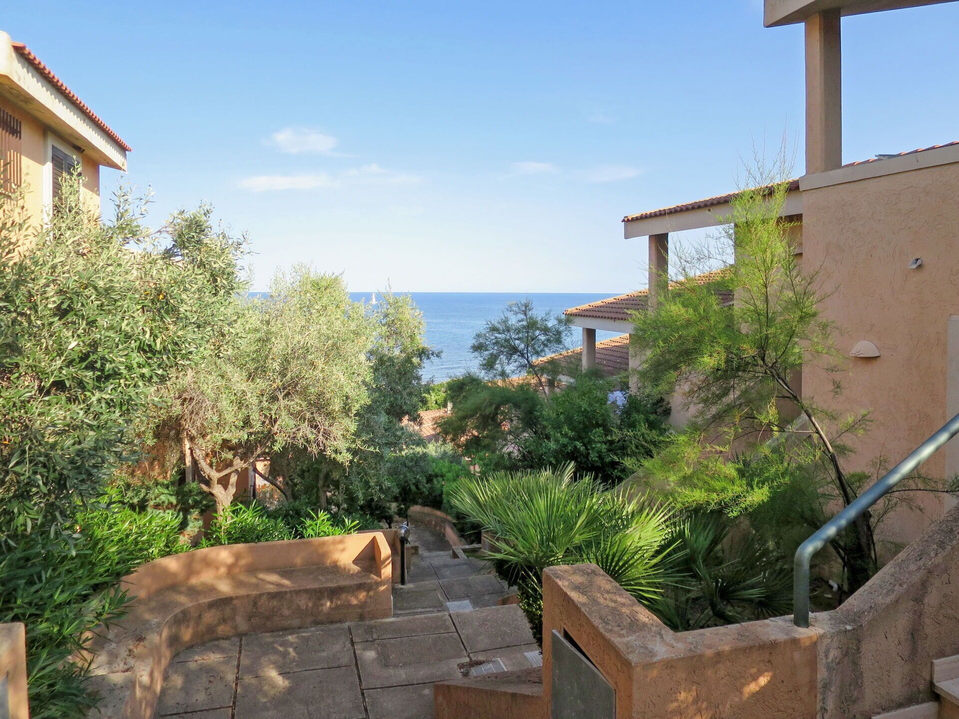 A staircase leading to a building with a view of the sea.