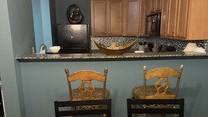 Un comedor con una mesa de madera, dos sillas y una bandeja con velas.