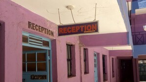 A reception area with a blue door labeled 'RECEPTION' and a sign above it. - Esidai Hotel (Mai Mahiu)