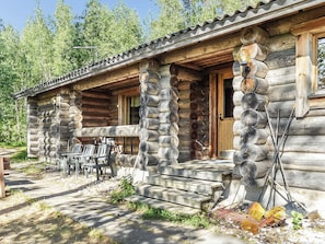 A log cabin with a porch, outdoor seating, and a door. - Matikkaniemi by Interhome (Punkaharju)