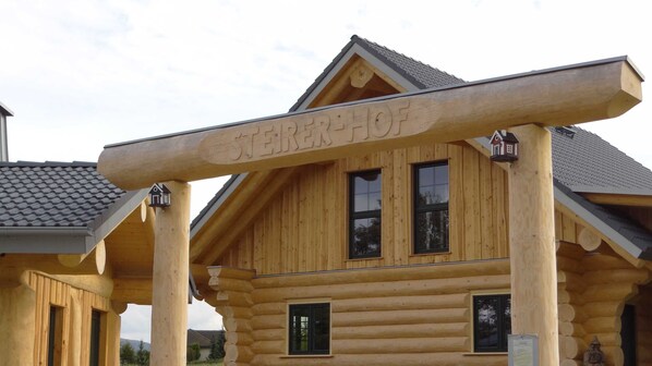 A log cabin with a prominent 'Sterehof' sign, multiple windows, and a sloped roof.