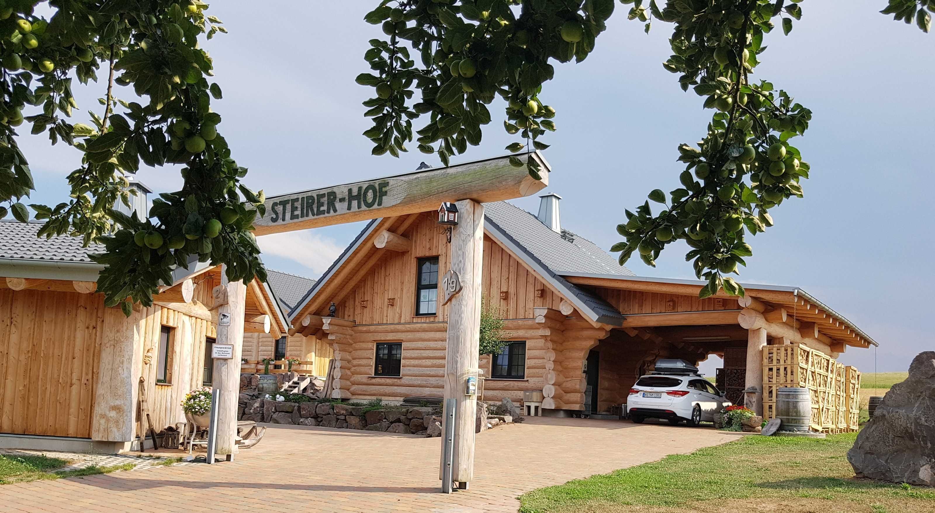 Une cabane en rondins de bois avec une enseigne indiquant « STEIER-HOF ».
