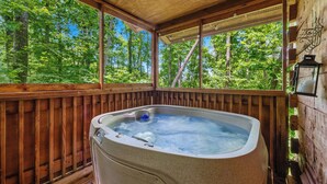 A hot tub in a wooden deck with a view of a forest. - Secluded Cabin w/ Hot Tub • King Bed • Smoky Mountains (Sevierville)