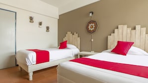 A hotel room with two beds, each with white bedding and red pillows, a wooden headboard, and a decorative wall hanging. - Hotel Allende 104 (Chihuahua)