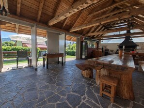 A covered outdoor area with stone flooring, wooden furniture, and a view of the outdoors. - Vacation home Maja by Interhome (Fužine)