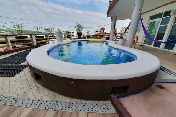A hot tub on a deck with a view of buildings in the background. - Hotel Casa Mia (Puerto Escondido)