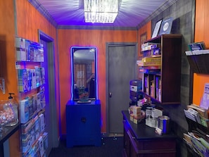 A narrow hallway with wooden walls, a blue cabinet, and shelves stocked with magazines and books. - Cabin-like Studio Motel Suite (Big Indian)