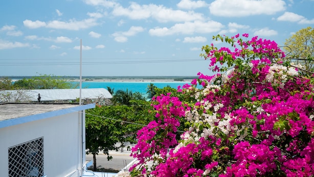 A coastal view with a building, a clear sky, and a beach in the background. - Hotel Casa Poblana (Bacalar)