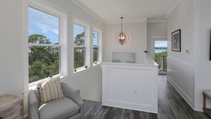 A modern interior with large windows, a grey sofa, and a pendant light.