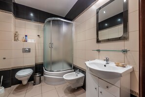 Apartamento | Banheiro | Chuveiro, secador de cabelo, toalhas de banho, shampoo