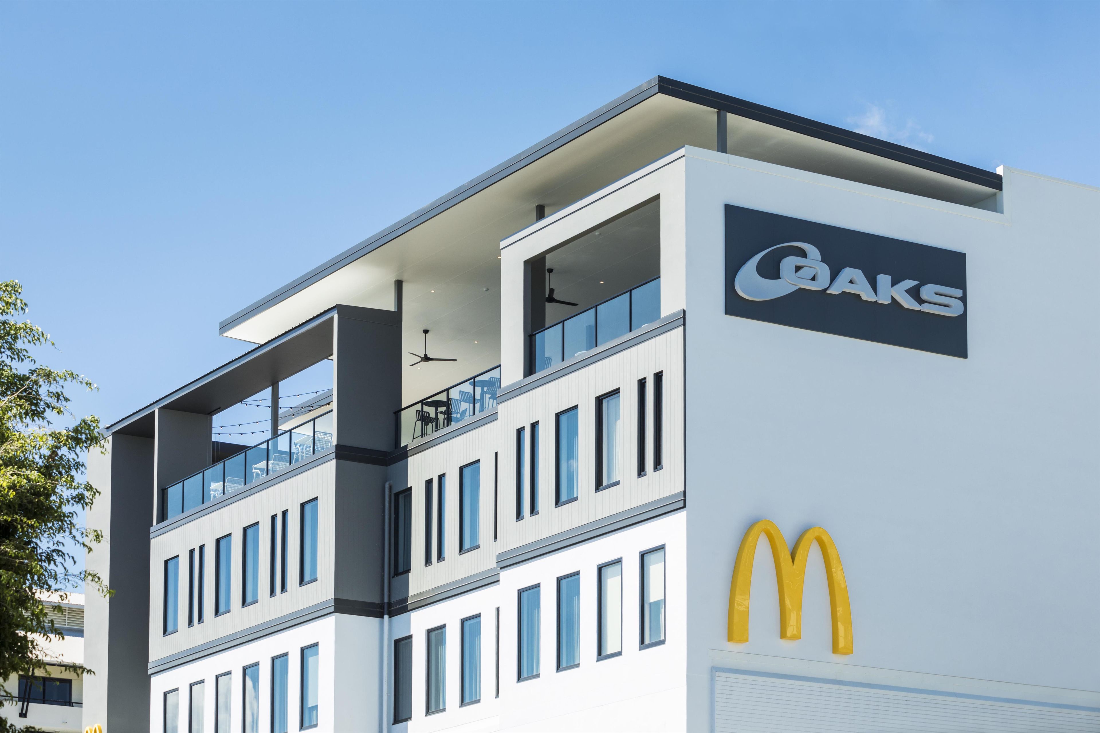 Un bâtiment moderne doté d’un toit plat, de grandes fenêtres et du logo de McDonald’s.