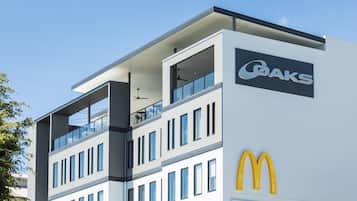 Un bâtiment moderne doté d’un toit plat, de grandes fenêtres et du logo de McDonald’s.