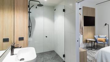 A modern bathroom with a shower, a sink, and a mirror.
