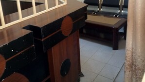 A room with a wooden cabinet, a bench, and a chair.