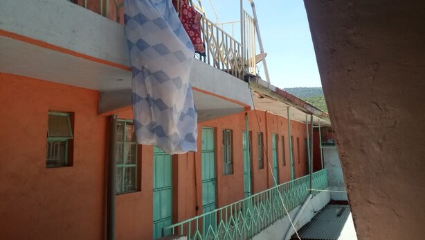 A multi-story building with balconies, a visible laundry hanging, and a clear sky. - Jordan Guest House (Mai Mahiu)