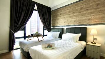Habitación de hotel con dos camas, cabecero de madera, mesita de noche con lámpara y vistas a la ciudad a través de amplias ventanas.