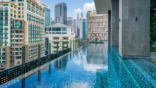 A modern hotel with a rooftop infinity pool, offering views of the city skyline and nearby buildings. - Anggun Residence by Sleepy Bear (Kuala Lumpur)