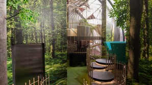 Un espace intérieur moderne, agrémenté d’une fresque murale sur le thème de la forêt, d’un escalier en colimaçon et de plusieurs coins salon.
