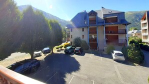 Un immeuble à plusieurs étages avec un parking situé devant.