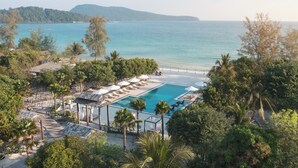 A resort with a pool, beach, and forested area.
